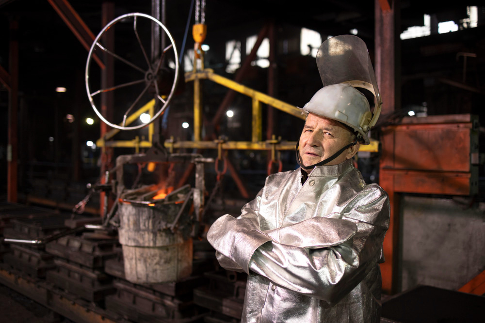 man working in foundry factory wearing a proximity suit and safety helmet