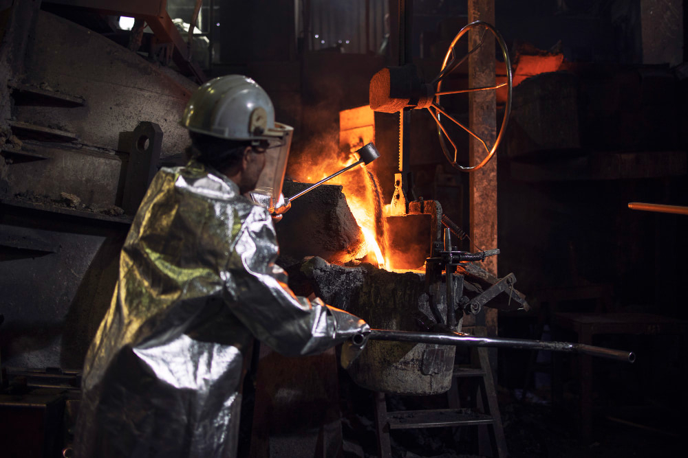 man working in foundry factory wearing a proximity suit and safety helmet