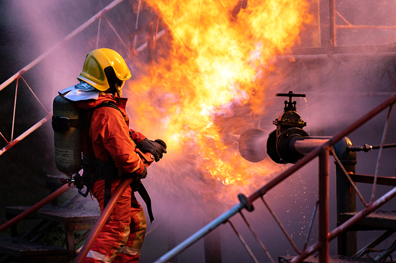 firefighter spraying water on an explosion