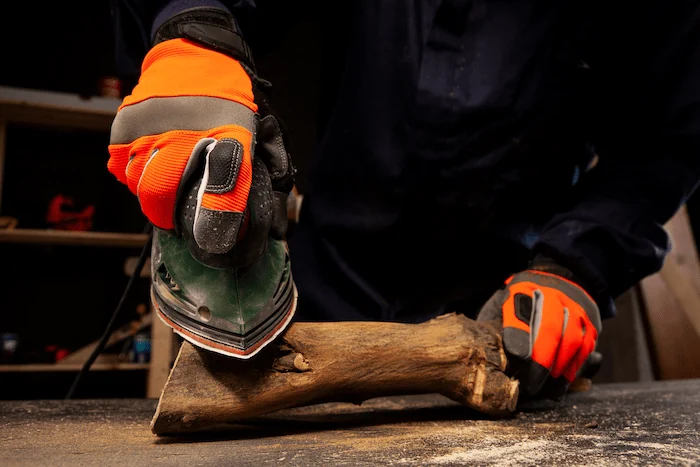 worker using gloves to cut wood